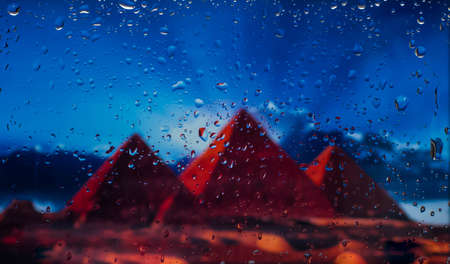 The Egyptian pyramids A view of the city from a window from a high point during a rain. Rain drops on glass. Focus on dropsの写真素材