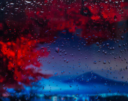mountains A view of the city from a window from a high point during a rain. Rain drops on glass. Focus on dropsの写真素材