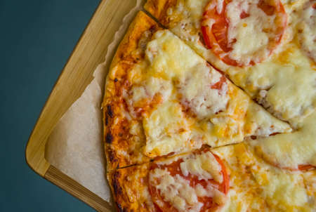 Slice of hot pizza large cheese lunch or dinner crust seafood meat topping sauce. with bell pepper vegetables delicious tasty fast food italian traditional on wooden board table classic in side view .の写真素材