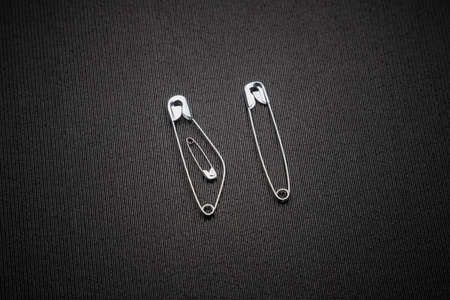 Safety pin clasp on clothing or shirt. pin in the form of a pregnant woman with a child next to her...