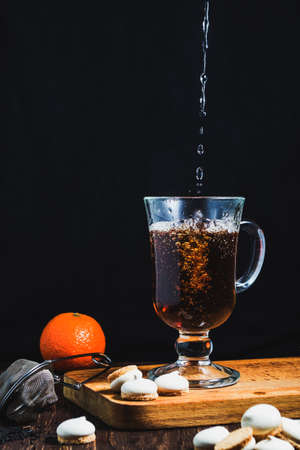 Hot tea pouring into a glassの写真素材