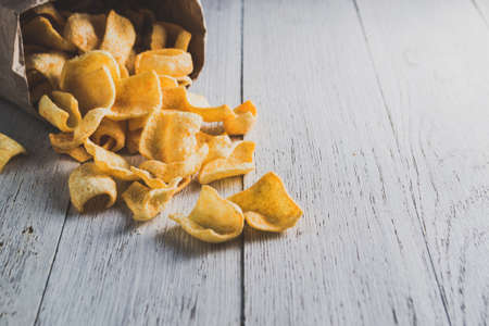 A bag of potato chips on wooden backgroundの写真素材