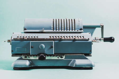 Old calculating machine on a green background. Accounting or business conceptの写真素材