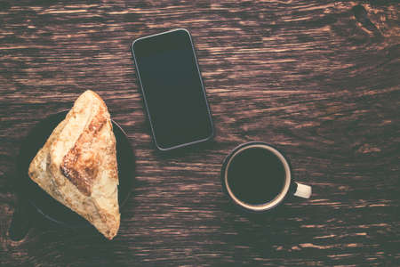 Coffee and bun on a dark wooden backgroundの写真素材