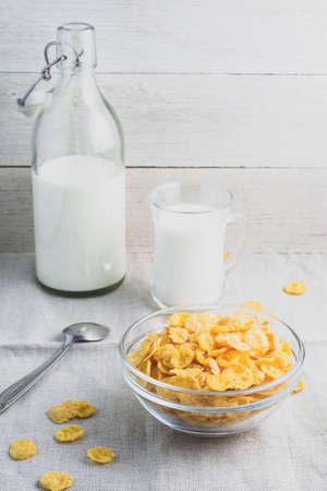 Cornflakes and milk on a light wooden background