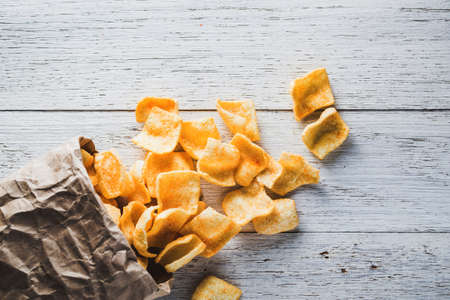 A bag of potato chips on wooden backgroundの写真素材