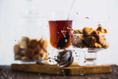Blurred image cookie and a Cup of tea through wet glassの写真素材