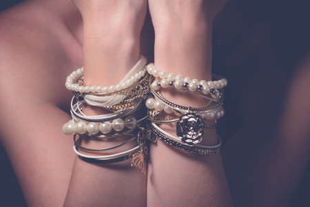 Collection of bracelets on the hands of a womanの写真素材