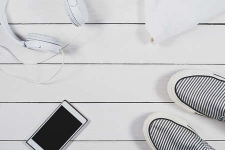 Gadgets and summer clothing on a bright wooden background