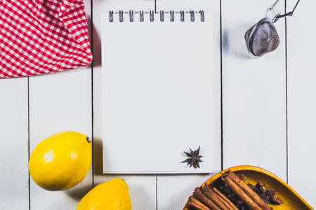 Mockup for recipe of tea or menu. Lemons and spices on a light wooden background