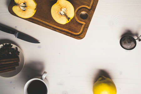 Yellow quince and tea on white wooden backgroundの写真素材