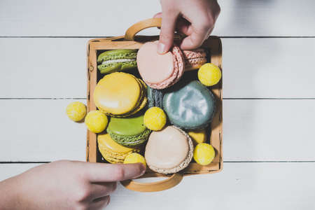 Cake macaron or macaroon in basket on light wooden backgroundの写真素材