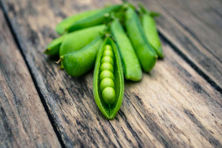 Green peas on a wooden tableの写真素材