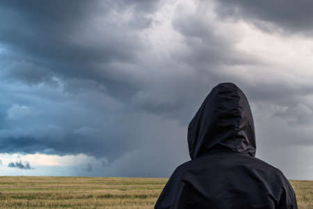 Man in a field before the stormの写真素材