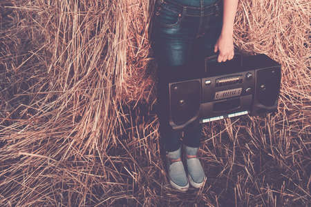 Woman holding an old cassette recorderの写真素材
