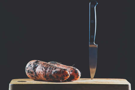 Knife and carrots on a black backgroundの写真素材