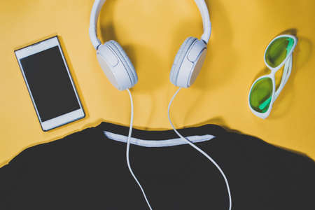 Gadgets and summer clothes on yellow backgroundの写真素材