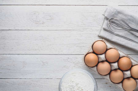 Eggs and ingredients for baking on a light wooden table. Top view and flat lay