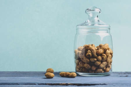 Peanuts in a jar on a green backgroundの写真素材