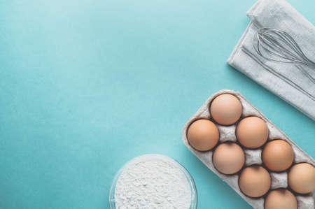 Eggs and ingredients for baking on a light green background. Top view and flat layの写真素材