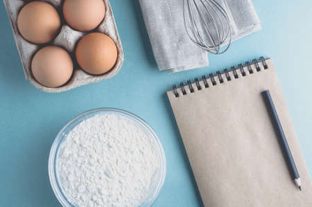 Eggs and ingredients for baking on a light green background. Top view and flat lay