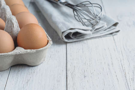 Eggs and ingredients for baking on a light wooden table
