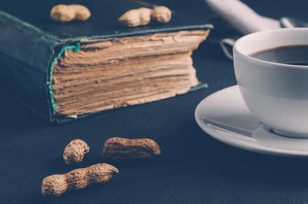Coffee Cup and book on dark background. The concept of Breakfastの写真素材