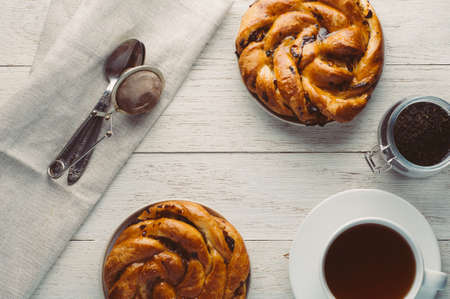 Cup of tea and bagel on white wooden backgroundの写真素材