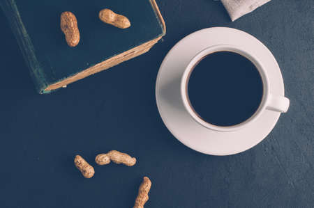 Coffee Cup and book on dark background. The concept of Breakfastの写真素材