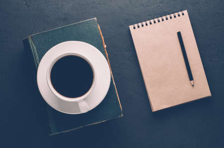 Coffee Cup and book on dark background. The concept of Breakfastの写真素材