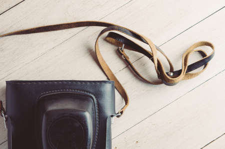 Old photo camera on white wooden backgroundの写真素材