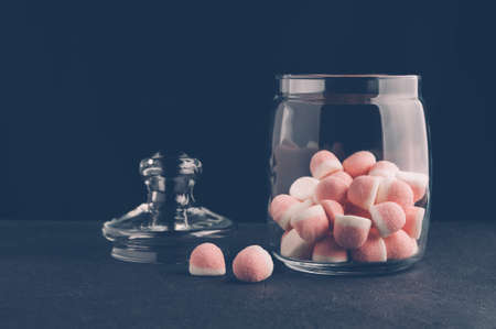 Pink candies in a jar on a dark backgroundの写真素材