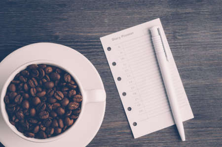 Cup with coffee beans on dark wooden backgroundの写真素材