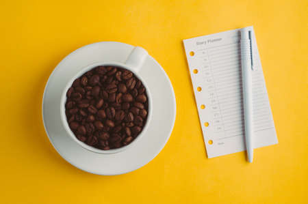 Cup with coffee grains  on a yellow backgroundの写真素材