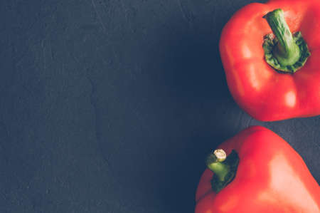 Fresh red peppers on a dark stone background