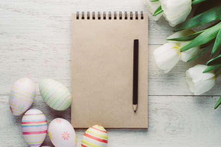 White tulips and Easter eggs on white wooden background. The concept of Easter or springの写真素材