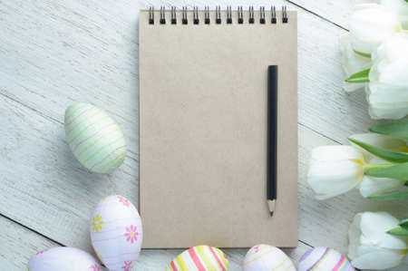 White tulips and Easter eggs on white wooden background. The concept of Easter or springの写真素材