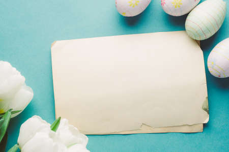 White tulips and Easter eggs on a green background. The concept of Easter or springの写真素材