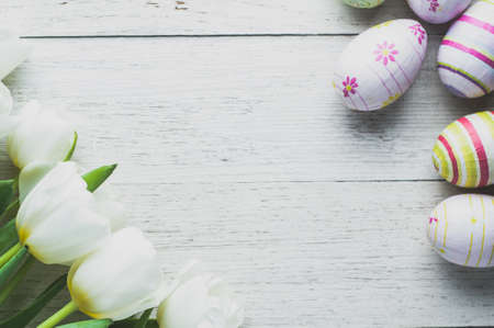 White tulips and Easter eggs on white wooden background. The concept of Easter or springの写真素材