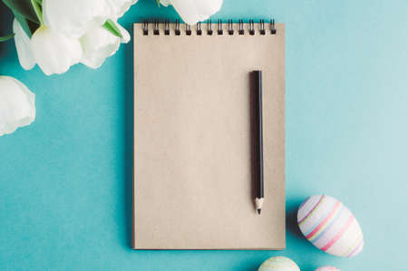 White tulips and Easter eggs on a green background. The concept of Easter or springの写真素材