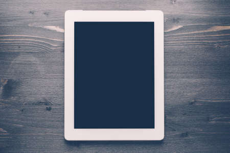 White gadget on a dark wooden backgroundの写真素材