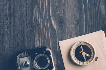 Old compass and camera on a dark wooden backgroundの写真素材
