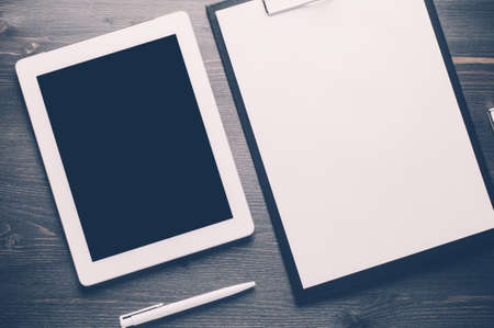 Gadgets and a notebook on a dark wooden backgroundの写真素材