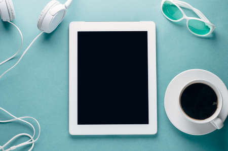 Cup of coffee and tablet PC on a green backgroundの写真素材