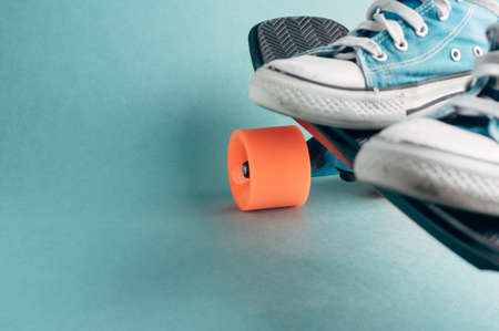 Skateboard and sneakers on a green background