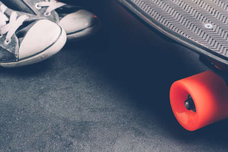 Skateboard and sneakers on a dark background