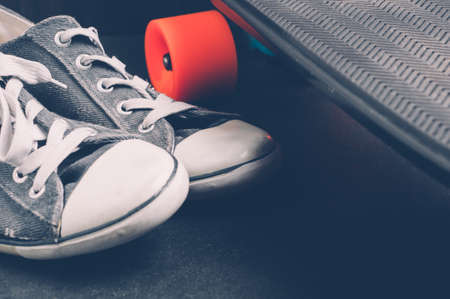 Skateboard and sneakers on a dark background