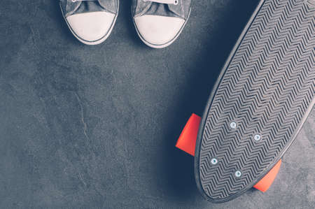 Skateboard and sneakers on a dark backgroundの写真素材