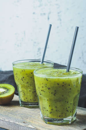 Fresh kiwi juice in glass over wooden background. Diet concept, healthy eating or weight loss. Space for text, vertical frameの写真素材