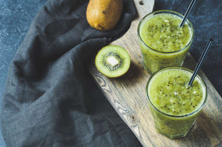 Fresh kiwi juice in glass on dark background. Diet concept, healthy eating or weight loss. Space for textの写真素材